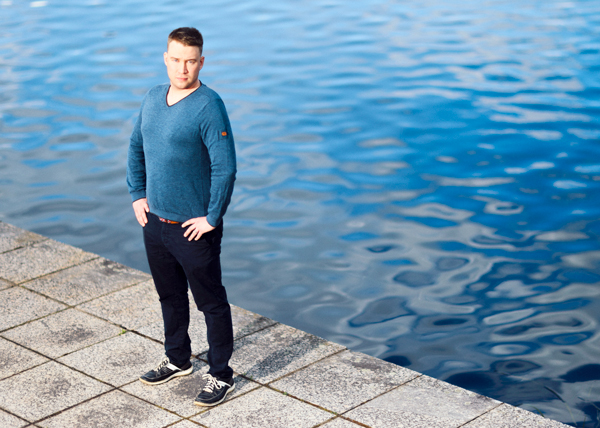 Altti Närä seisoo käden lanteilla veden äärellä.