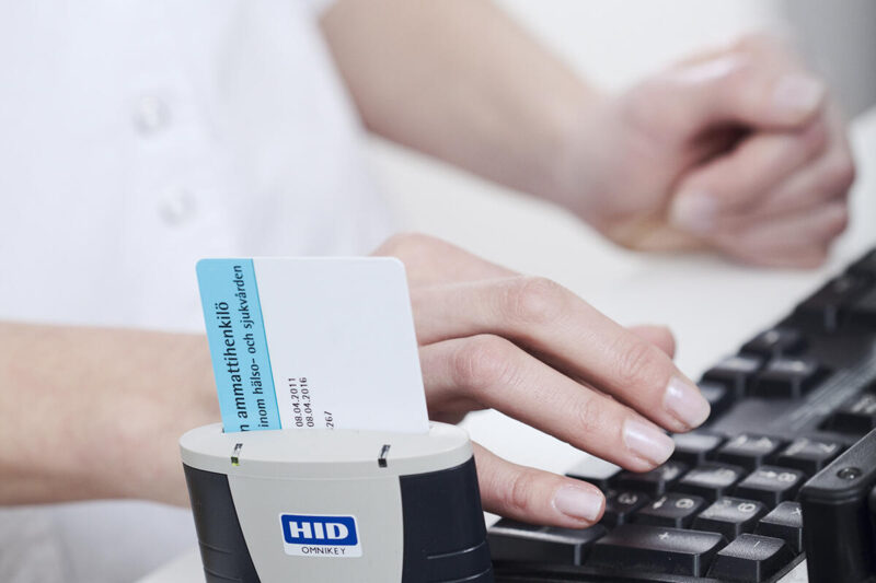 Farmaseutti tietokoneella, varmennekortti lukijassa.