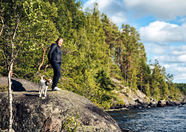 Auli Riihiaho ja Hilla-koira seisovat kalliorannalla.
