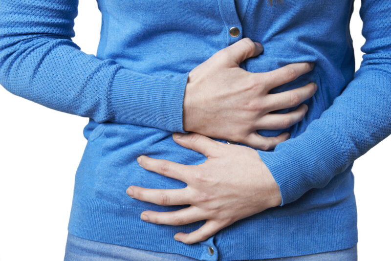 nainen pitelee vatsaansa