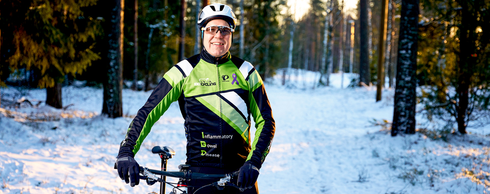 Teemu Ramstedt poseeraa pyörän kanssa ja hymyilee kameralle.