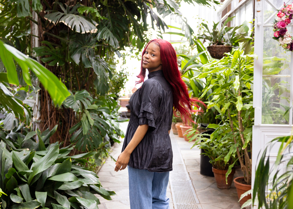 Nainen kasvien keskellä.