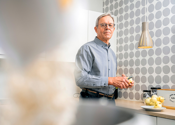 Mies hymyilee keittiössä.