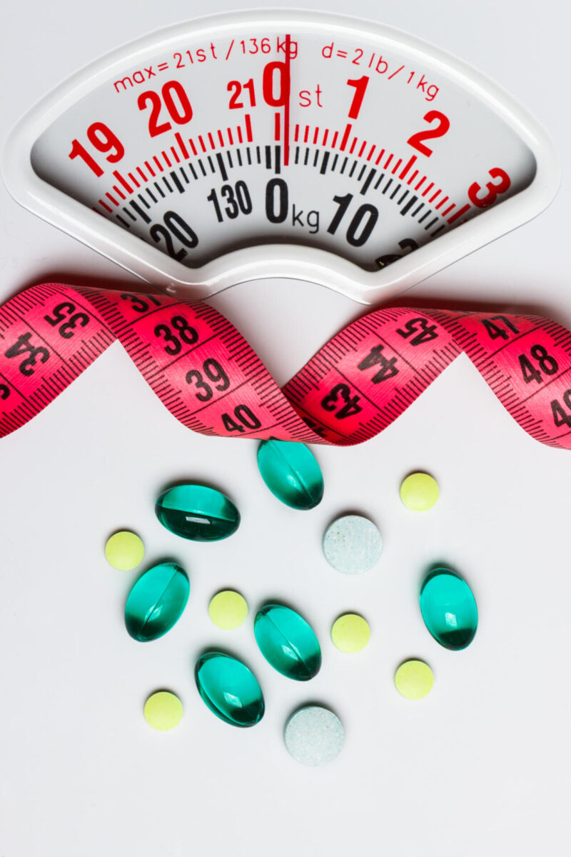 Vaaka, mittanauha ja pillereitä