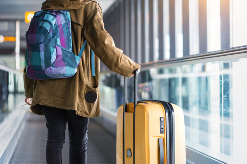 ihminen lentokentällä matkalaukun kanssa