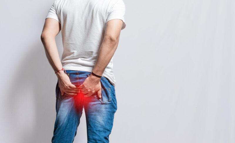 Mies pitelee kiinni takapuolesta