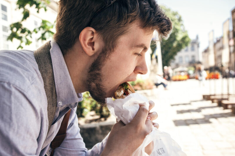 Mies syö hampurilaista