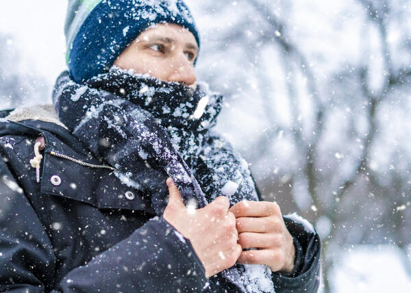 Mies palelee pakkasessa.