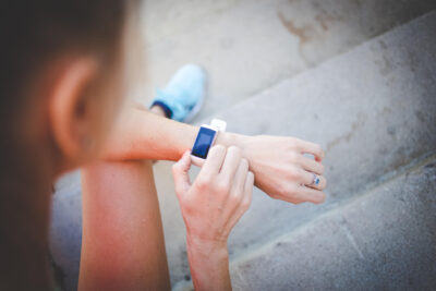 Nainen on lähdössä lenkille ja säätää älykelloa.